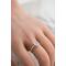 Sterling silver ring with oval faceted moonstone set in a bezel setting with simple silver ring band modeled on a female hand 